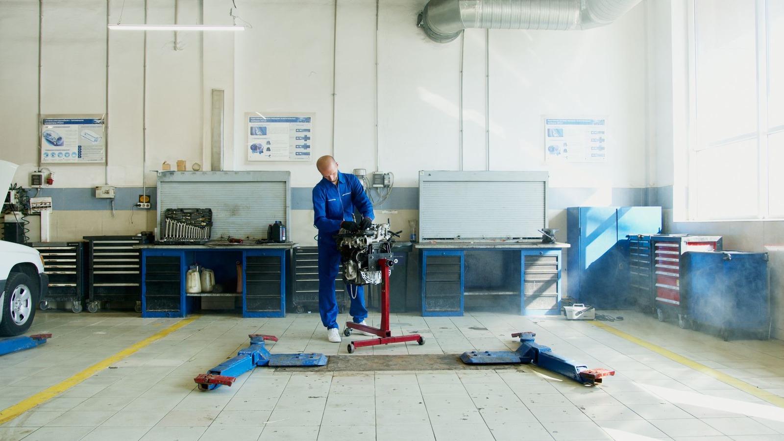 A wide, bright workshop floor with vehicle lifts and equipment bays
